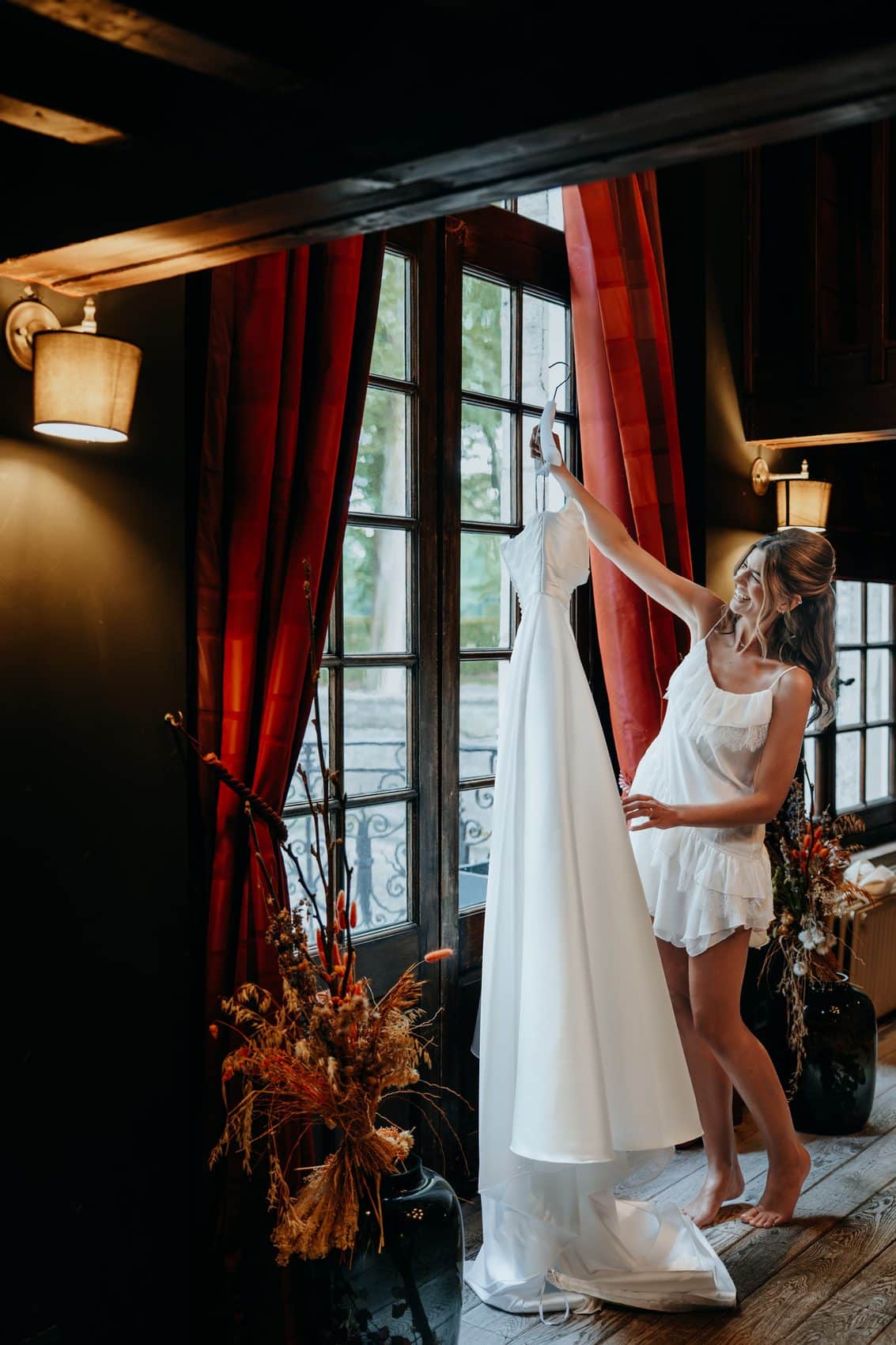 Agathe décroche sa robe devant la fenêtre