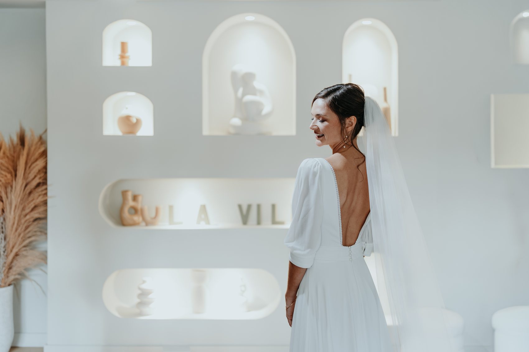 Chloé en robe, de dos, le voile sur l’épaule