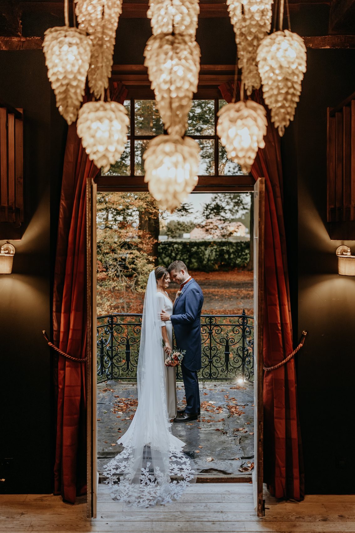 Chloé et Cyril dans l’embrasure de la porte, sous les lustres