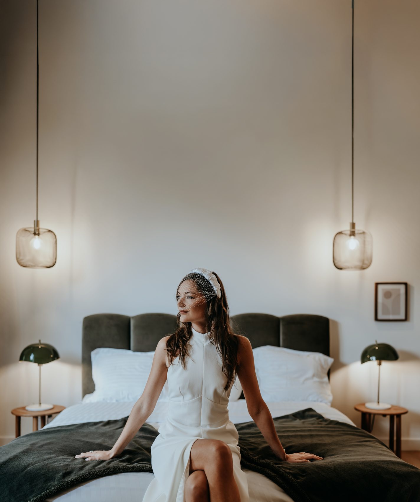 Chloé assise sur le lit, en tenue de mairie